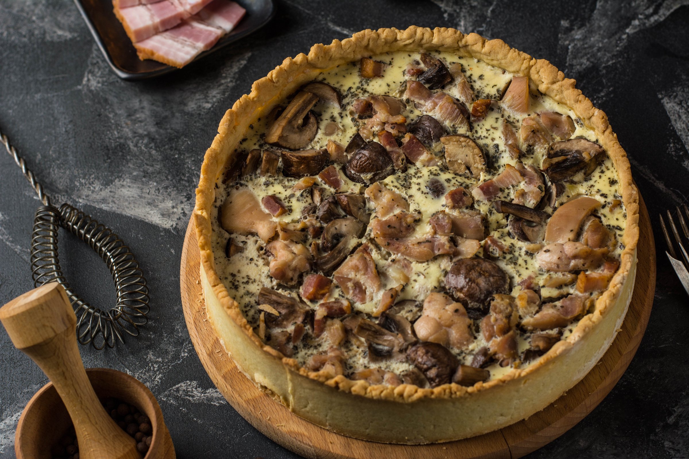 Mushroom Quiche Pie with champignons and cheese on dark background, top view. Savory tart with mushrooms. Galette. Tart with chicken. Chicken pie. Mushroom pie.